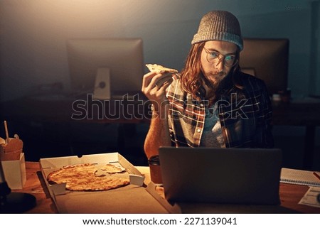 Web designer, man with pizza at laptop and night shift, overtime and deadline at digital marketing agency. Content research, reading and serious male at desk, working late at startup eating fast food Royalty-Free Stock Photo #2271139041