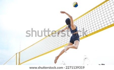 Sports, volleyball and woman jump at beach to hit ball in competition, game or match. Training, exercise and female athlete jumping for spike in tournament for workout, fitness and health at seashore Royalty-Free Stock Photo #2271139319