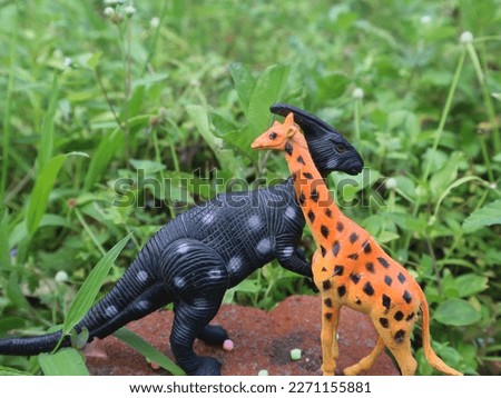 A fierce battle between the orange giraffe and the black dinosaur is underway, children's toys