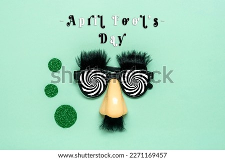 funny face - fake eyeglasses, nose and mustache, calendar date 01 April on green background Happy fools day concept  1st April party Holiday greetind card