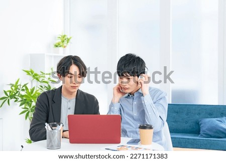 Young casual asian men group looking at laptop PC together. Video editor. Desk top music. DTM. Royalty-Free Stock Photo #2271171383
