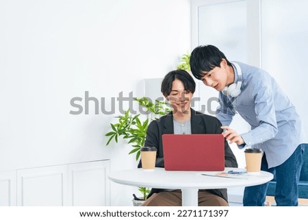 Young casual asian men group looking at laptop PC together. Video editor. Desk top music. DTM. Royalty-Free Stock Photo #2271171397