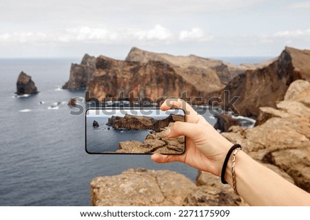 Taking photos of the cliff coastline. Using mobile phone in travel