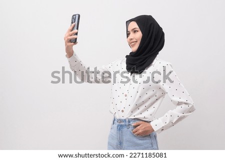 Beautiful musllim woman with hijab using smartphone over white background, technology concept. 		