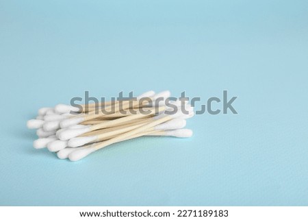 Wooden cotton buds on light blue background. Space for text Royalty-Free Stock Photo #2271189183