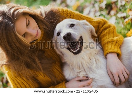 Belgrade, Serbia. November 10th, 2022. Young beautiful woman looking at her golden retriever and having fun in a park on a sunny day.