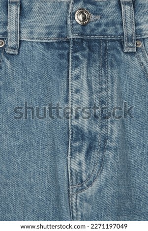 detail of blue denim trousers with button and seams