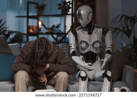 Sad boy losing a video game, he is playing with an android AI robot Royalty-Free Stock Photo #2271198727