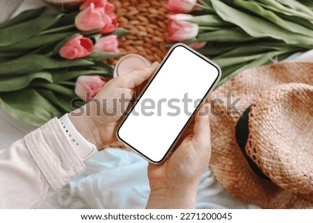 Mobile phone and spring flower pink tulips on the pink background. Theme of love, mother's day, women's day flat lay