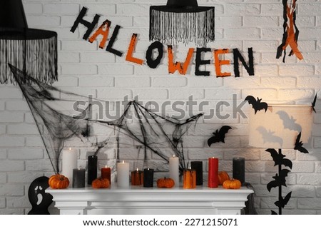 Fireplace with different Halloween decor indoors. Festive interior
