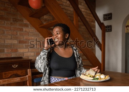 Healthy young woman living with HIV on the phone at home in South Africa