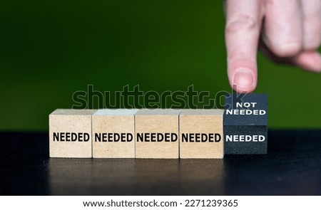 Needed and not needed. Hand turns cube and changes the expression 'needed' to 'not needed'. Royalty-Free Stock Photo #2271239365