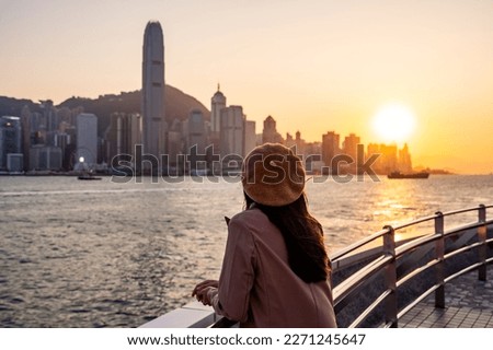 Young woman traveler relaxing and enjoying the sunset atmosphere at Victoria harbour in Hong Kong Royalty-Free Stock Photo #2271245647