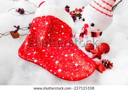 christmas decoration, smiling snowman with Christmas stocking on white snow background