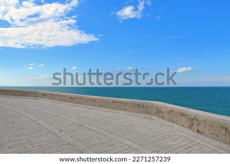 Panoramic view from the street on the old stone walls of town of Termoli with Adriatic sea and cloudy blue sky in background, Termoli, Italy Royalty-Free Stock Photo #2271257239