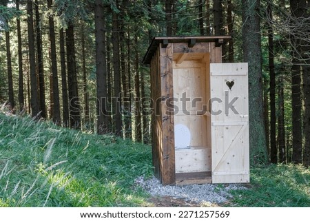 New open wooden outdoor toilet, outhouse in forest in beskids mountains. Royalty-Free Stock Photo #2271257569