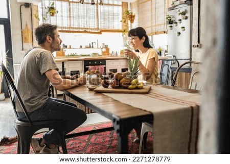 nice mature couple having breakfast together at dining table, happy