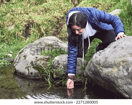 Embracing the Wild: Woman Hiking and Splashing Through a River