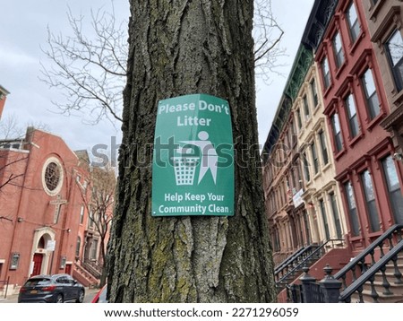 "Please Don't Litter Help Keep Your Community Clean" sign posted to a tree on a residential street in Harlem, New York City
