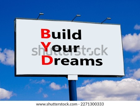 BYD build your dreams symbol. Concept words BYD build your dreams on big white billboard against beautiful blue sky background. Clouds. Business and BYD build your dreams concept. Copy space.