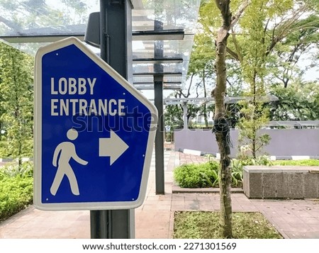 Closeup of Signs on pathway to guide pedestrians from the parking area to the lobby entrance. Road marking, traffic rules. Pedestrian guidance.