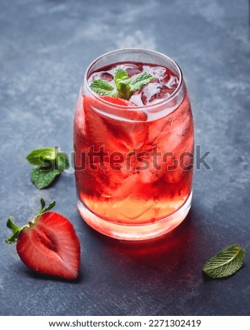 Strawberry cocktail with ice and mint leaves on a dark background. Refreshing summer drinks and cocktails, close up