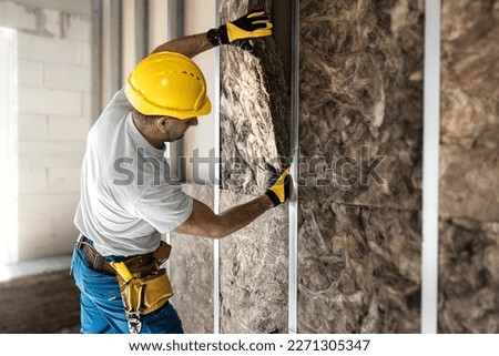 Placing acoustic insulation in a plasterboard konstruksion. Royalty-Free Stock Photo #2271305347