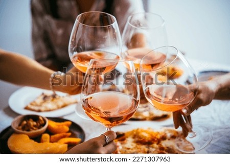 Friends enjoy a home rose wine party with pizza. Royalty-Free Stock Photo #2271307963