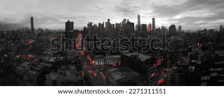 Red lights of the New York City skyline shining against a black and white cityscape in Lower Manhattan NYC
