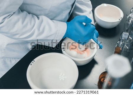 Professional pharmacist grinding a medical preparation using a mortar and pestle, pharmacy and medicine concept. Selective focus and little bit of foreground and depth of field Royalty-Free Stock Photo #2271319061