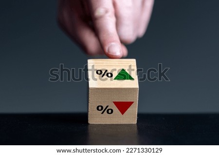 Symbol for the trend of the interest rate. Hand turns wooden cube and changes the orientation of an arrow from down to up. Royalty-Free Stock Photo #2271330129