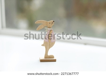 Handmade Easter bunny. Blurred background. Easter toys. Wooden Easter eggs on white background, copy space.