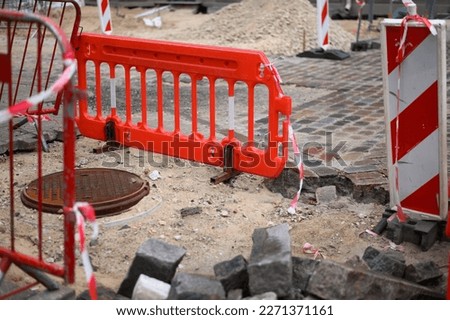 Road works in the city, red barriers and surface repair