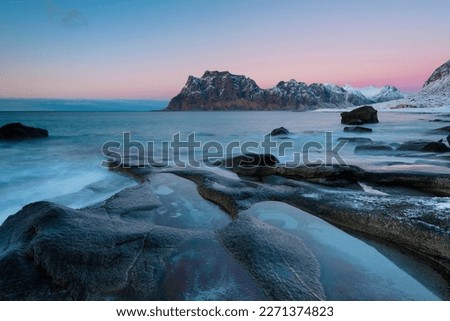 Rock in the sea, back mountains, sunset, Utakleiv, Lofoten, Norway Royalty-Free Stock Photo #2271374823
