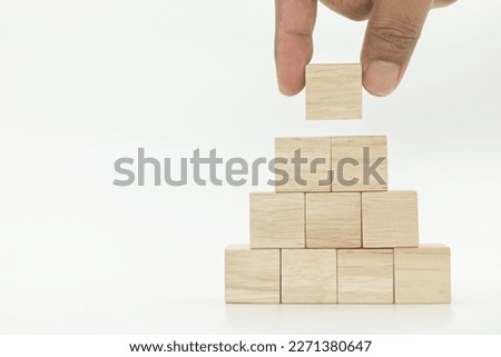 hand picking up wooden blank block cube on white background.