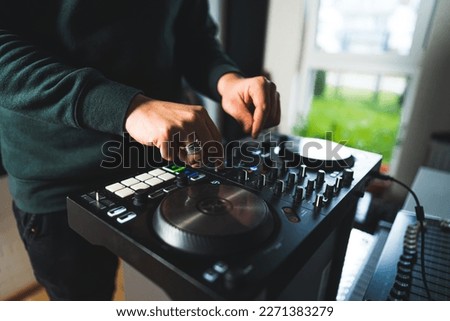 young man using his sound mixer and synthesizer in a home studio, closeup music concept. High quality photo