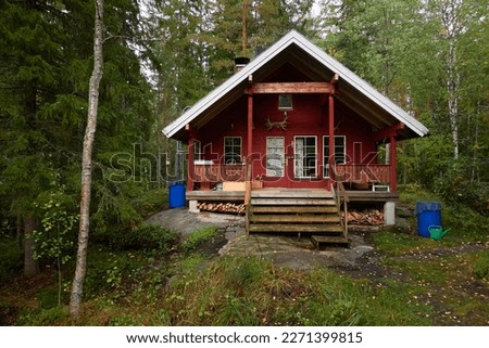 Traditional wooden house in the middle of majestic evergreen forest. Finland. Autumn rural landscape. Nature, eco tourism, vacations, weekend getaway, alternative lifestyle Royalty-Free Stock Photo #2271399815