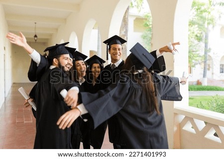 Excited group of friends hugging together and smiling looking happy after receiving their college diploma at their graduation Royalty-Free Stock Photo #2271401993