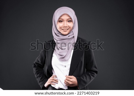Beautiful asian muslim woman model in formal office attire posing over an isolated background studio