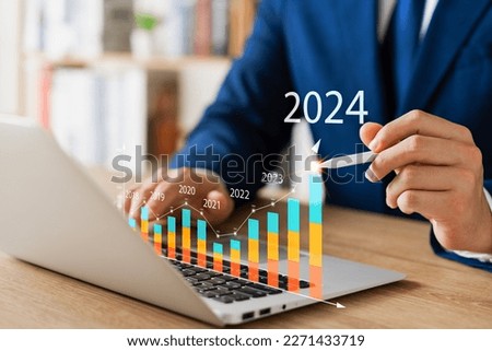 Businessman analyzes profitability of working companies with digital augmented reality graphics, positive indicators in 2024, businessman calculates financial data for long-term investments. Royalty-Free Stock Photo #2271433719