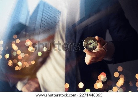 man in suit holding golden compass on background