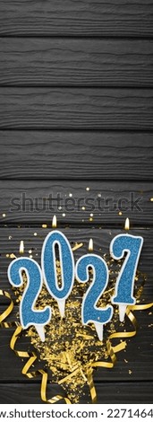 New year 2027 celebration greeting card background blue numbers 2027 with golden party decoration, confetti on dark wooden background. Flat lay, Merry Christmas,happy New Year holidays vertical banner