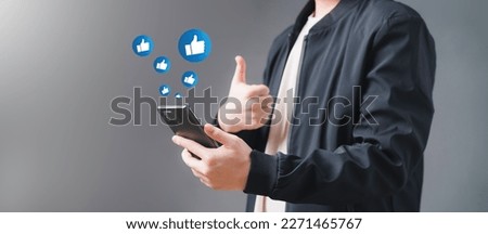 Young man Like and using smart phone with Social media. The concept of Social media and digital online. Watch Live streaming and Like message, likes, emoji feedback. Royalty-Free Stock Photo #2271465767