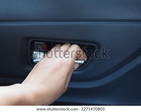 Woman hand open inner car door panel. 