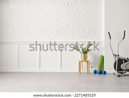 Decorative modern new style sport room in the house, mat, dumbbell, bike and white background wall.
