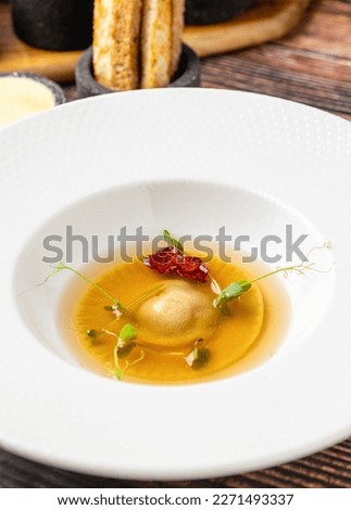 Ravioli consomme on a white porcelain plate. Healthy eating concept Royalty-Free Stock Photo #2271493337