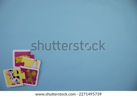 Educational puzzle pieces with pictures of cheese, mouse, milk and cow mixed in the lower left of the blue background.