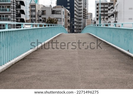pedestrian bridge over the river in the city Royalty-Free Stock Photo #2271496275