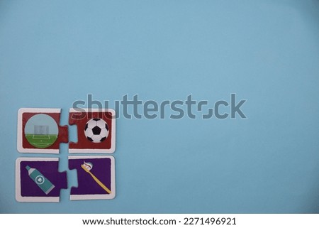 Educational puzzle pieces with pictures of soccer ball, soccer goal, toothpaste, toothbrush, placed at lower left on blue background.