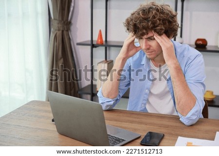Young adult businesswoman touching his head on table in office after bad news business failure or get fired and feeling discouraged, distraught and hopeless in modern office. 
